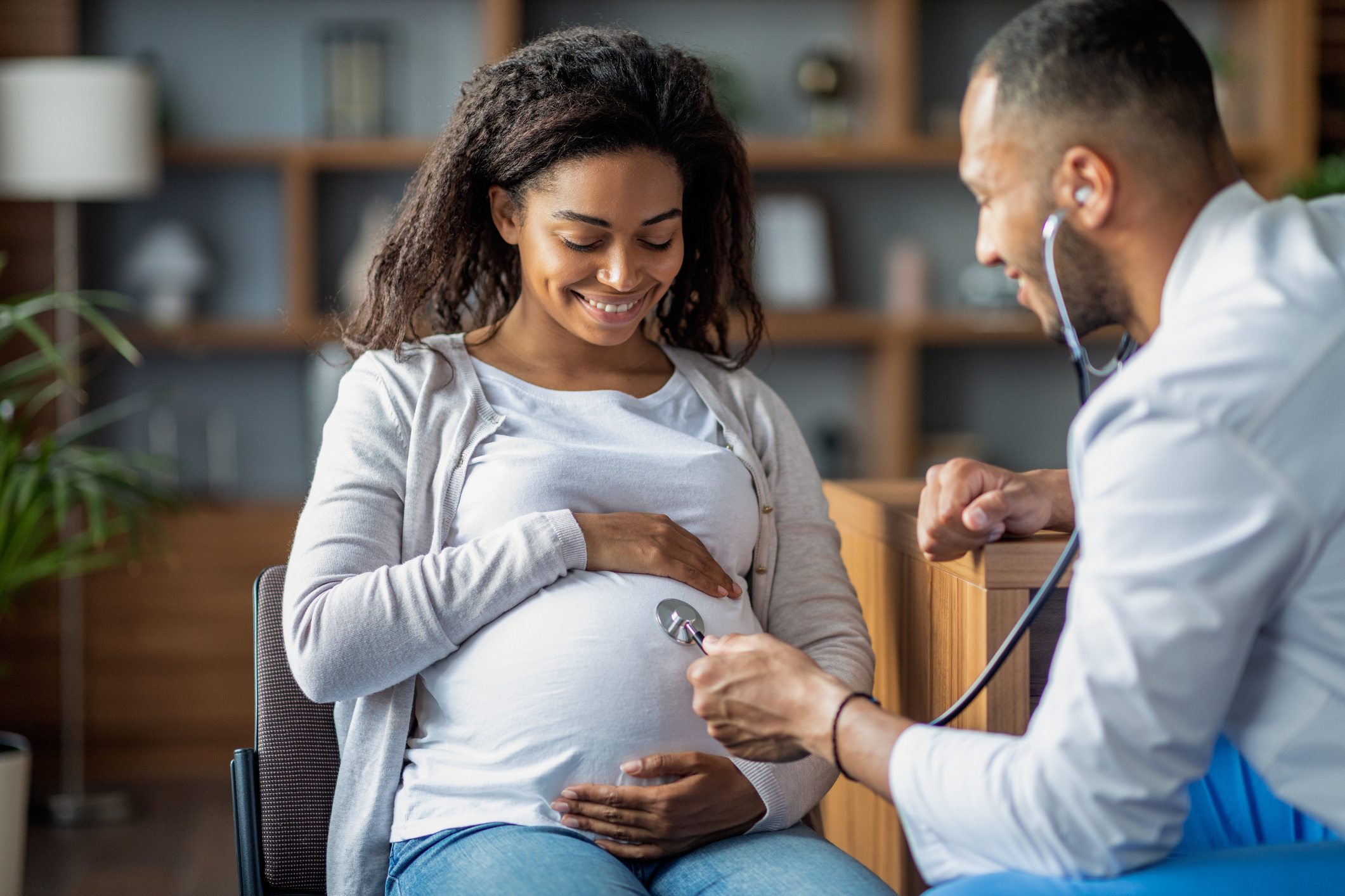 Mulher afro-americana grávida que visita o médico ginecologista